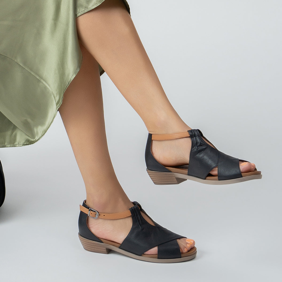 Le Sansa Digby black and tan sandals featuring open-toe design, ankle straps, and stylish leather material.