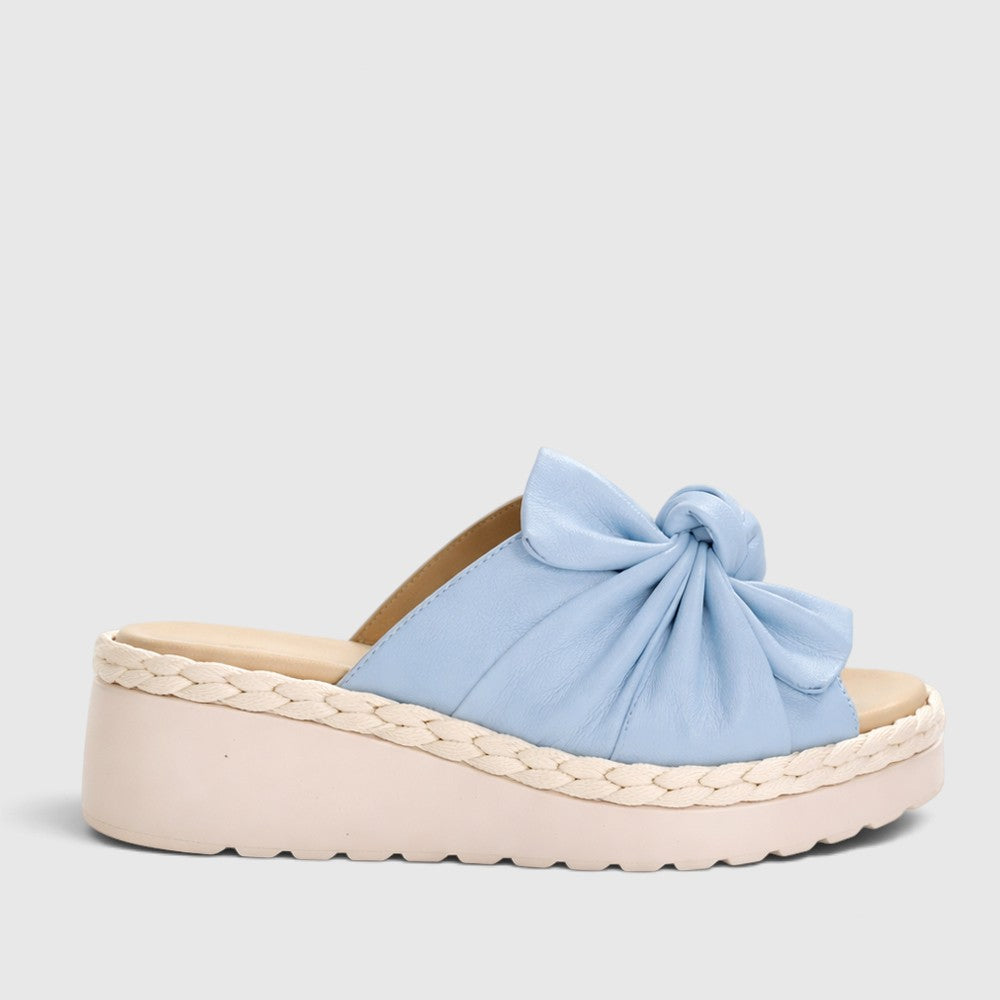 Le Sansa Eudore baby blue slip-on shoes for toddlers with soft fabric and flexible sole, displayed on a white background.