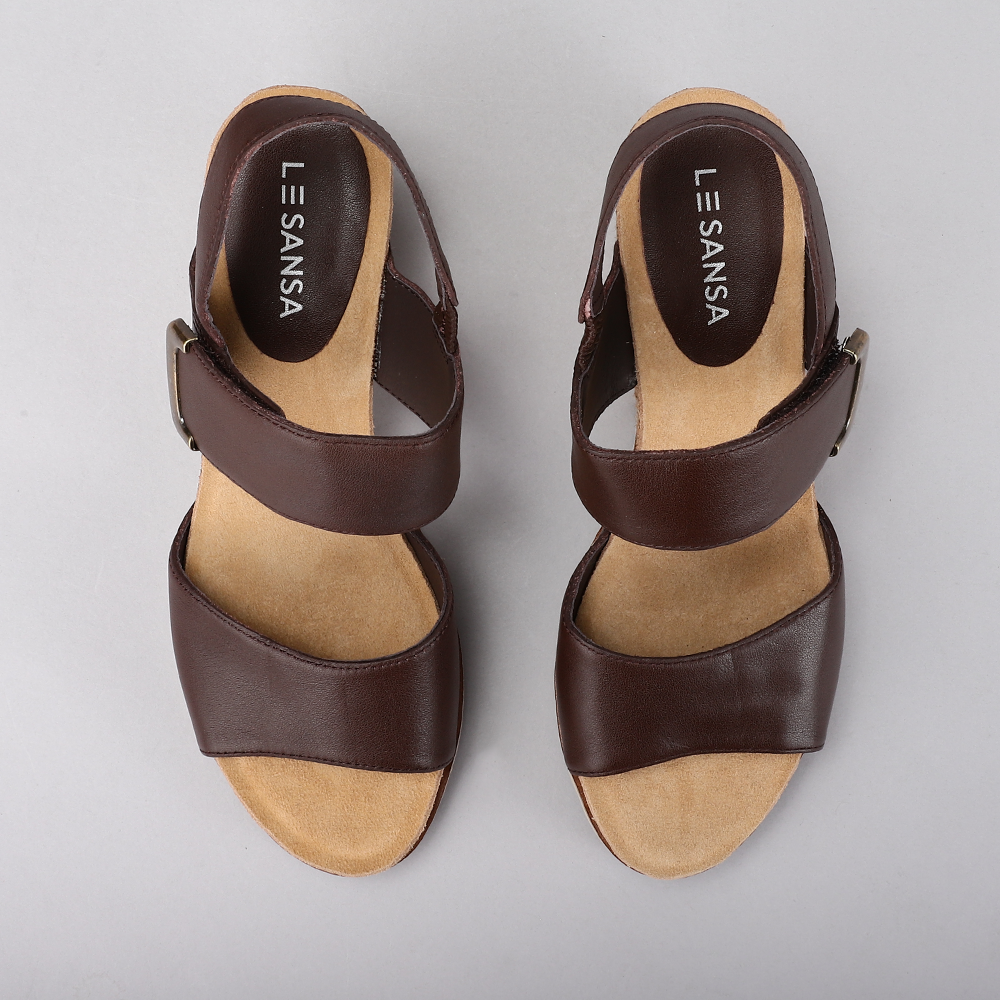 Le Sansa Evita chocolate sandals with open toes and ankle straps, featuring a stylish leather design.