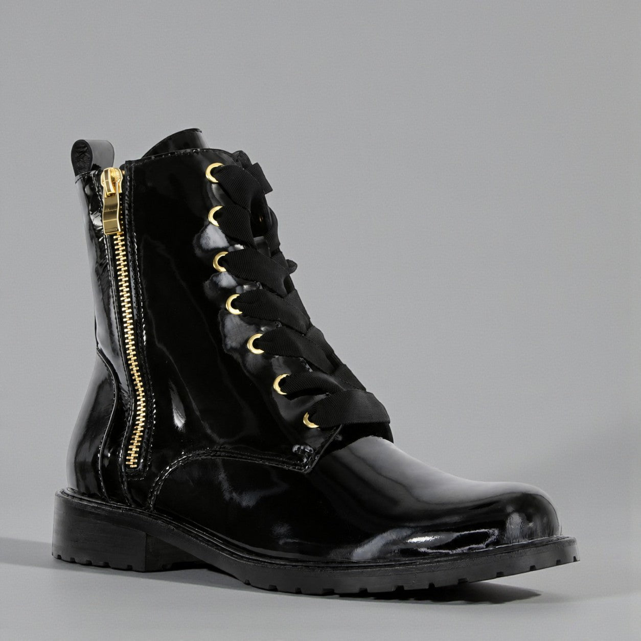 Black LE SANSA Sansa Fin patent boots with pointed toes and sleek design, shown in a close-up of the stylish footwear.