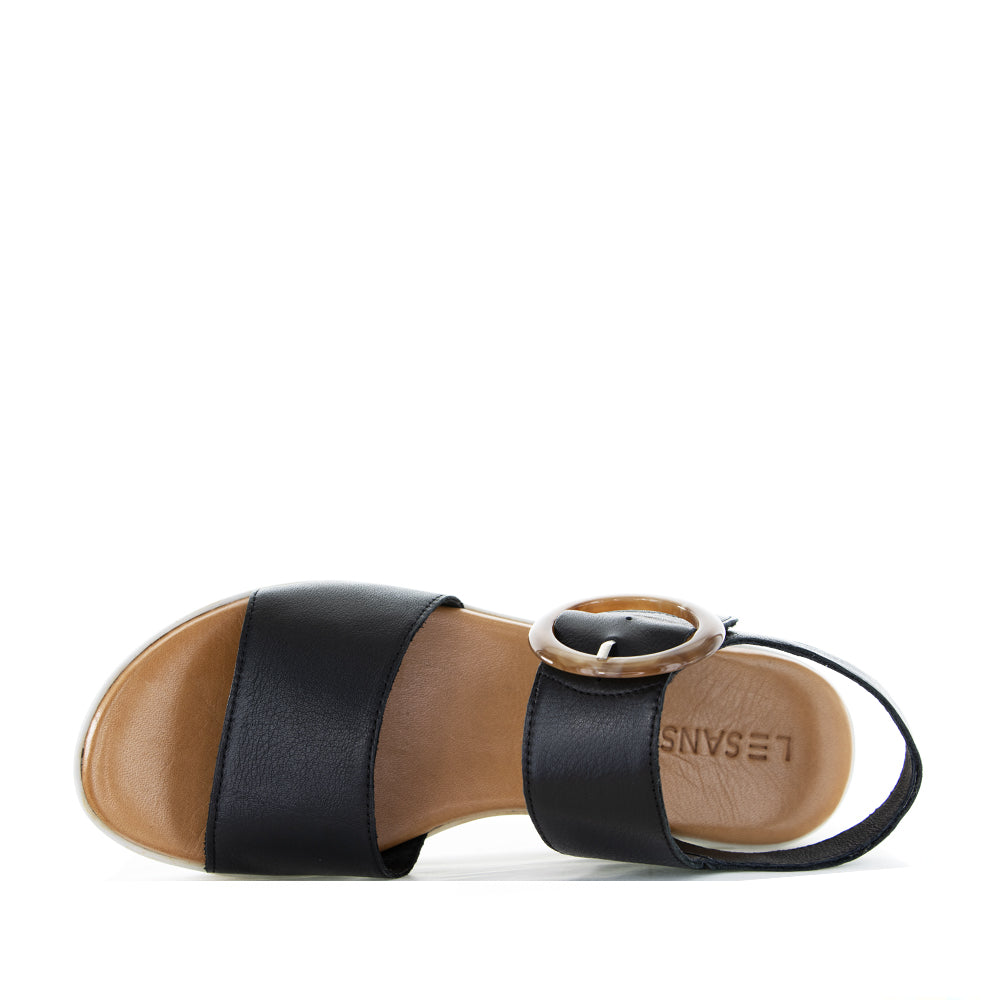 Black Le Sansa Guard sandals with open-toe design and strap details, displayed on a neutral background.