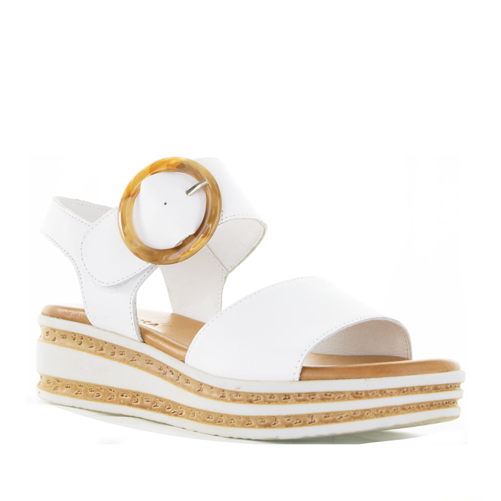 White Le Sansa Guard sandals featuring a sleek design and comfortable straps, shown on a model's feet.