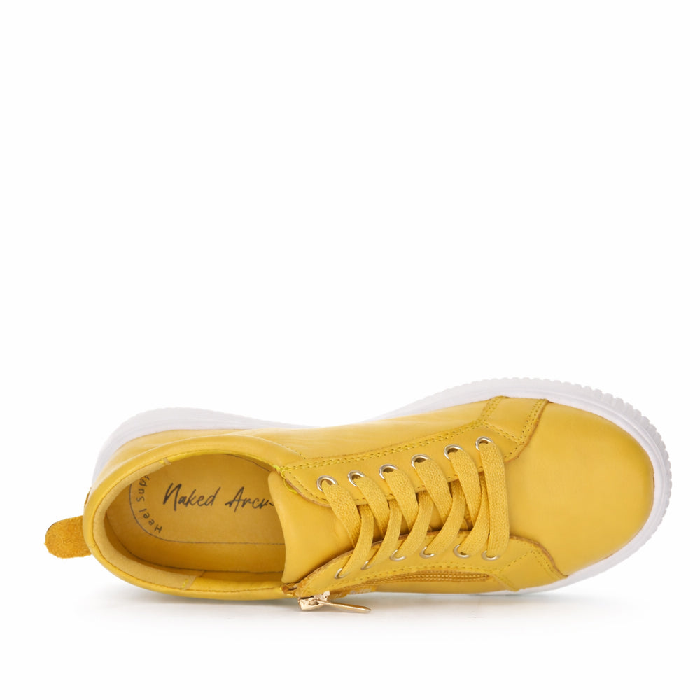 Naked Arches Nelly Mustard sneakers with mustard yellow suede and white rubber soles, stylish casual footwear.