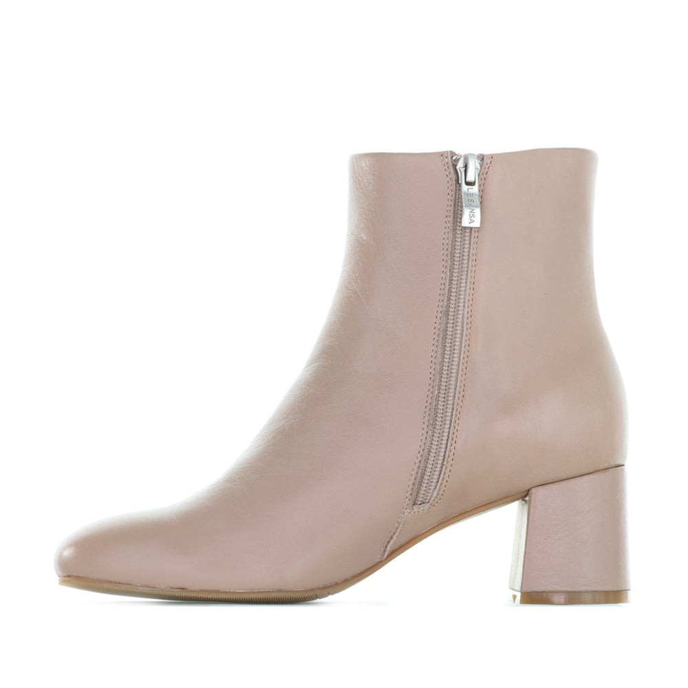 Le Sansa Rocket Taupe boots featuring a sleek design and taupe leather finish, shown on a model's feet.