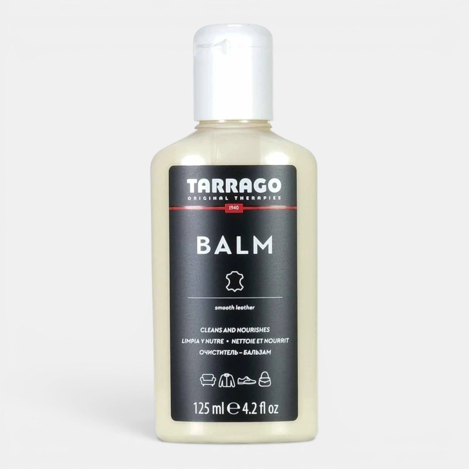 Zeke Collection Tarrago leather balm shoe care product in a shopping setting, showcasing packaging and application tools.