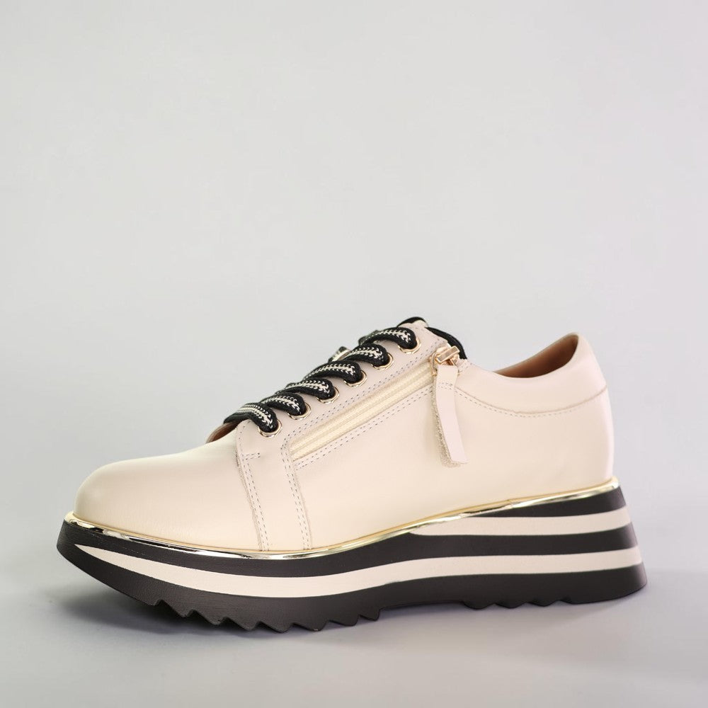 Le Sansa Skippa Cream sneakers featuring a sleek design with cream-colored leather and stylish laces.