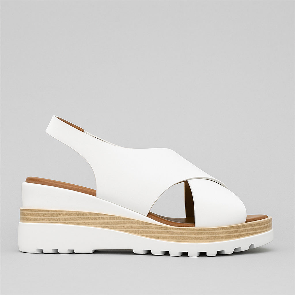 Le Sansa Trisha White sandals featuring open-toe design and ankle straps, perfect for casual summer wear.
