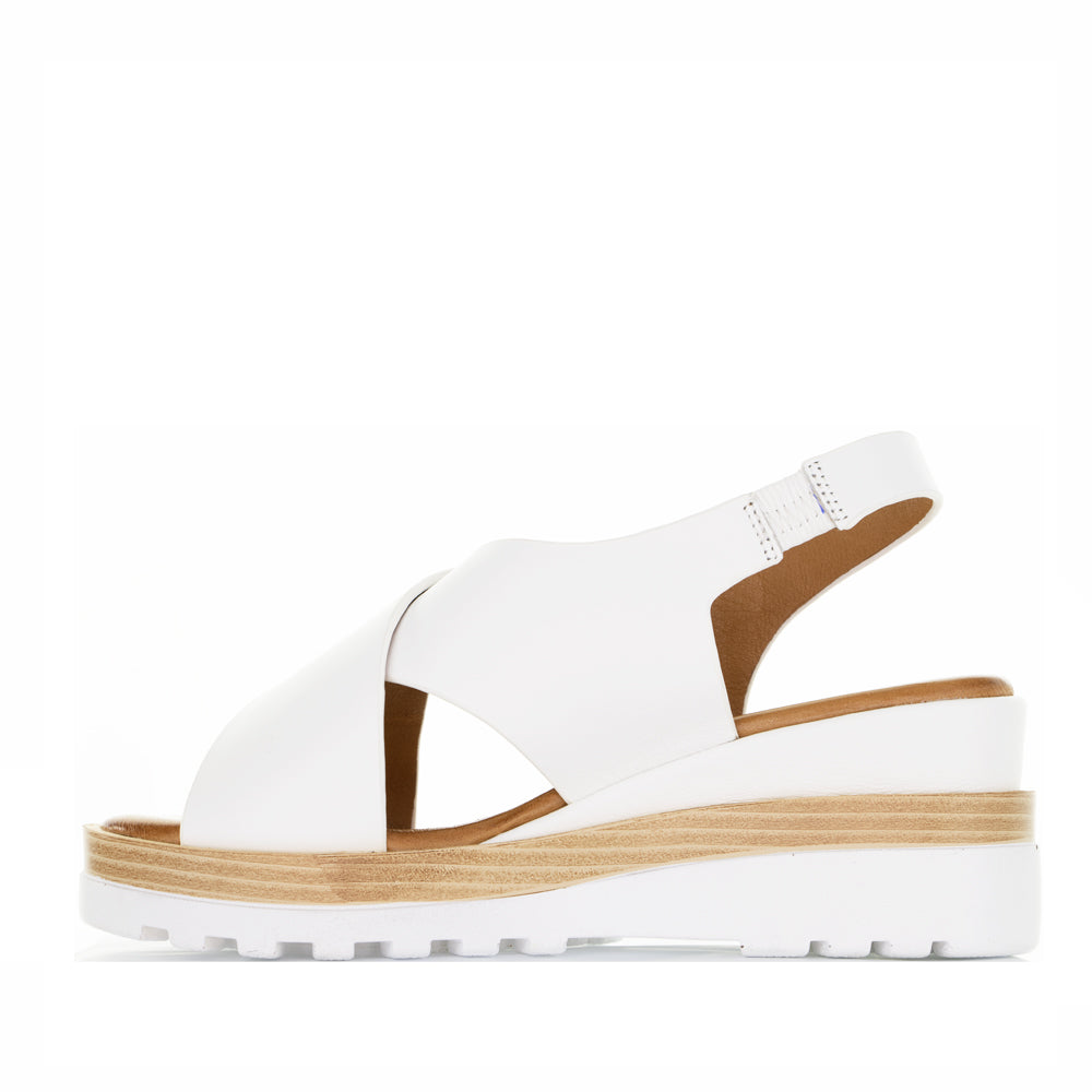 Le Sansa Trisha white sandals featuring a sleek design and open-toe style, perfect for casual summer wear.