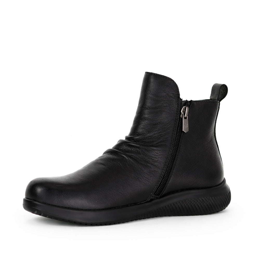 Black Naked Arches Yila boots with sleek ankle design and chunky heel, showcasing stylish footwear by Naked Arches.