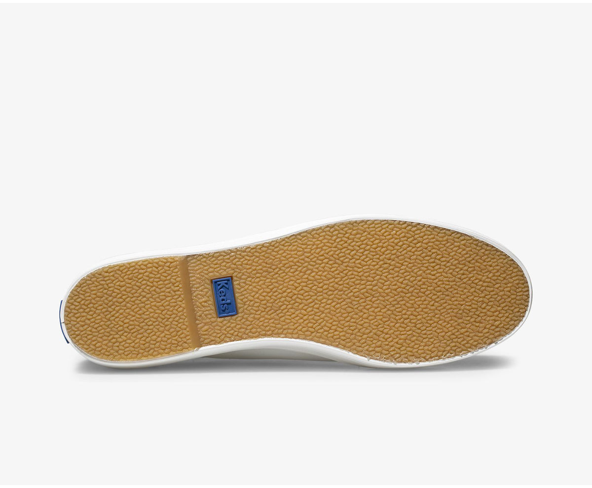 White KEDS Triple Kick sneakers with classic design, featuring white laces and rubber sole, on a clean background.