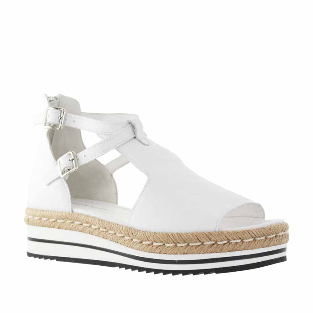 Django & Juliette Alexys white sandals with open toes and ankle straps, stylish footwear for warm weather.