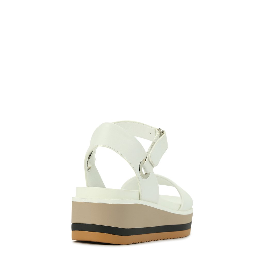 LOS CABOS Zita White sandals featuring sleek straps and a comfortable flat sole, perfect for casual summer wear.
