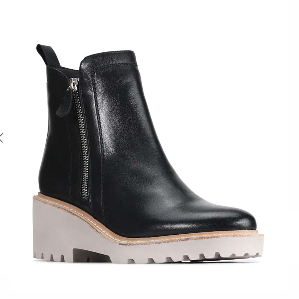 Eos Parson Black boots featuring sleek leather design and sturdy sole, styled with minimalistic modern footwear.